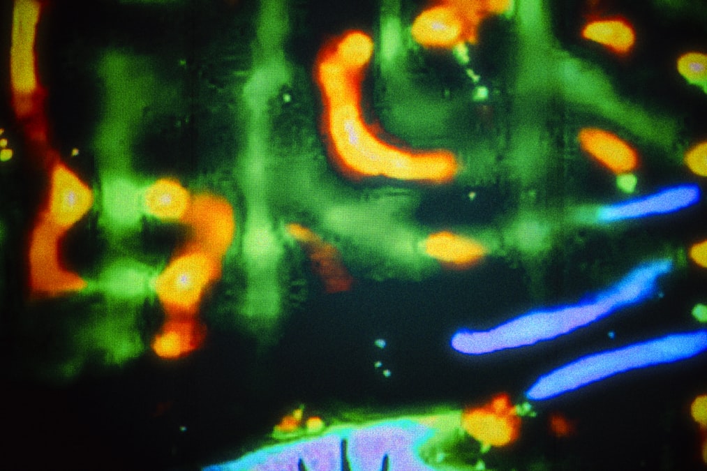 Abstract, colorful streaks and splatters on a dark background.