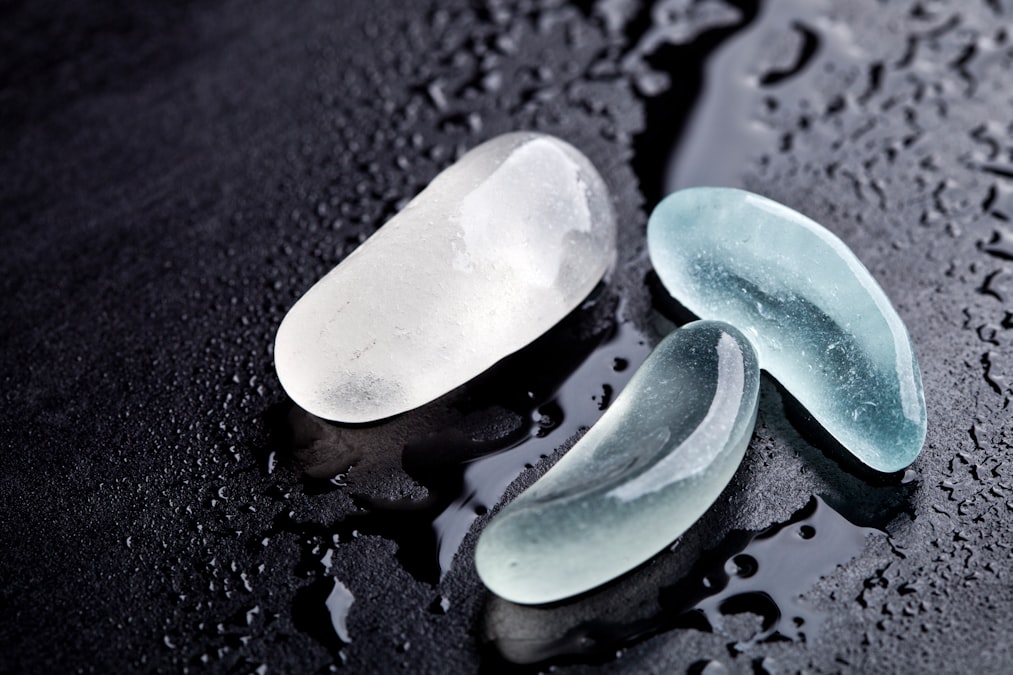 Three pieces of glass sitting on top of a wet surface