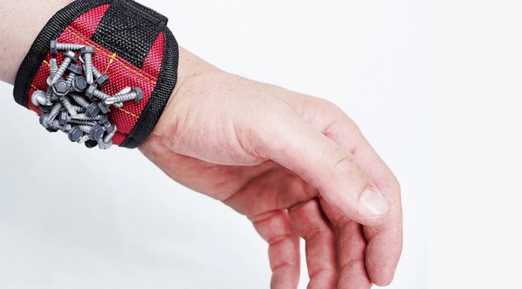 A hand holding a bunch of screws on it's wrist
