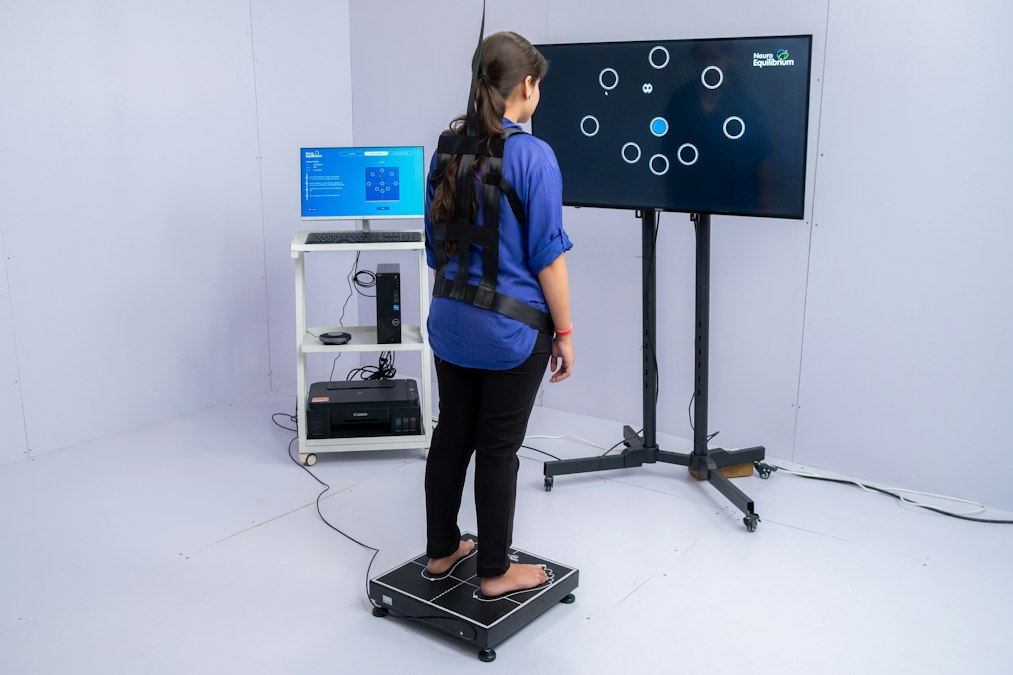 Woman stands on pressure plate with sensors on-screen interactive game