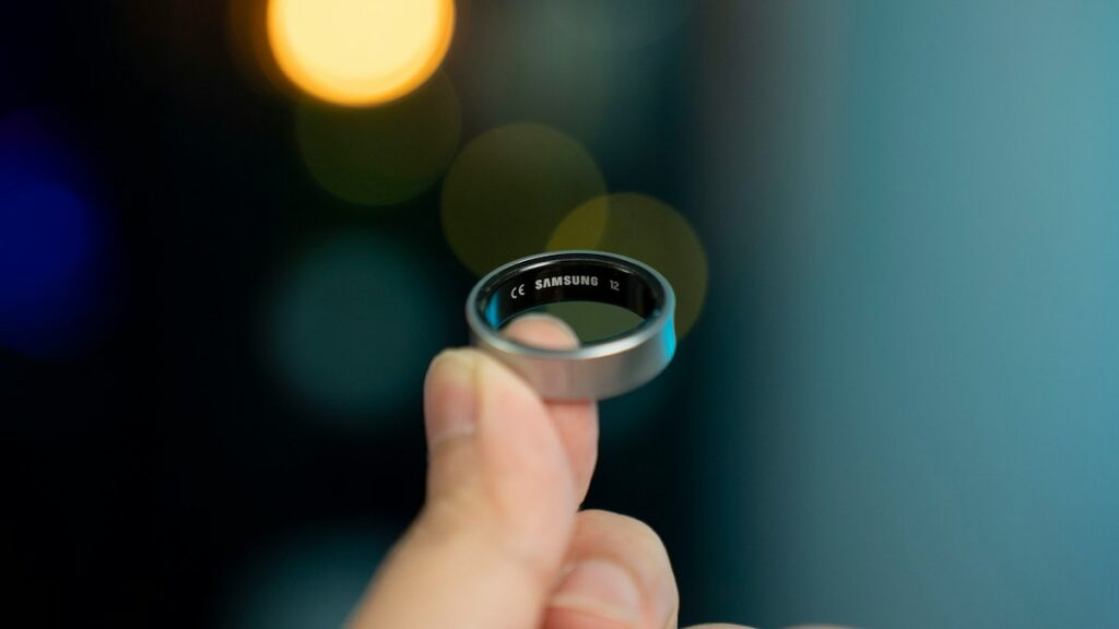 A hand is holding a smart ring