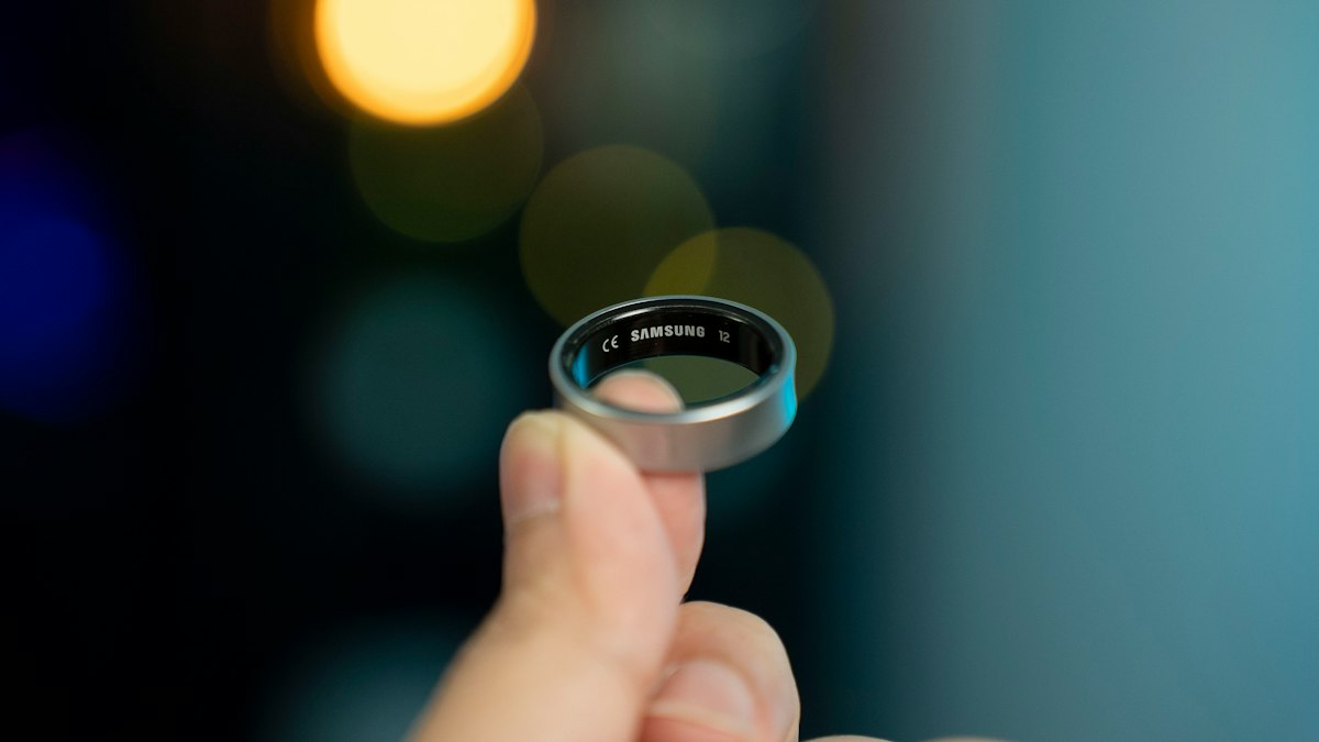 A hand is holding a smart ring
